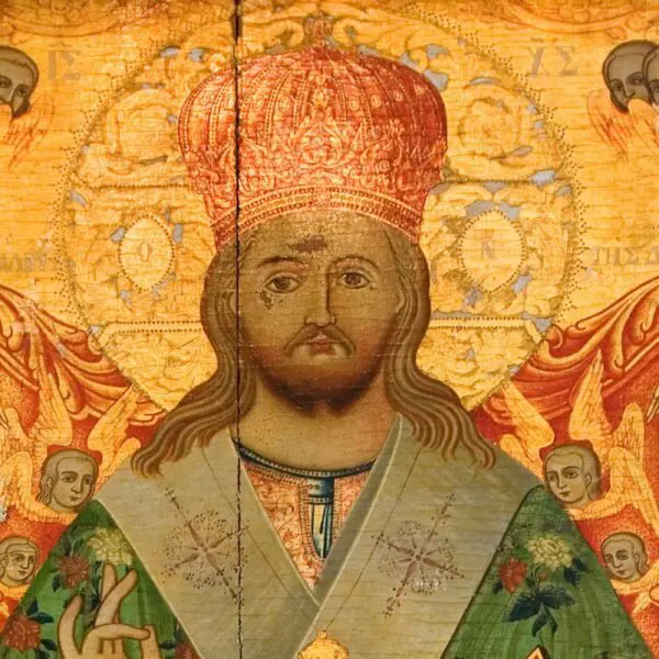 A religious icon resembling a calendar mural depicts a central figure with a halo, adorned in ornate robes and a crown, surrounded by angelic figures. Golden patterns dance across the textured background. This visual tour captivates with its intricate detailing and spiritual symbolism.