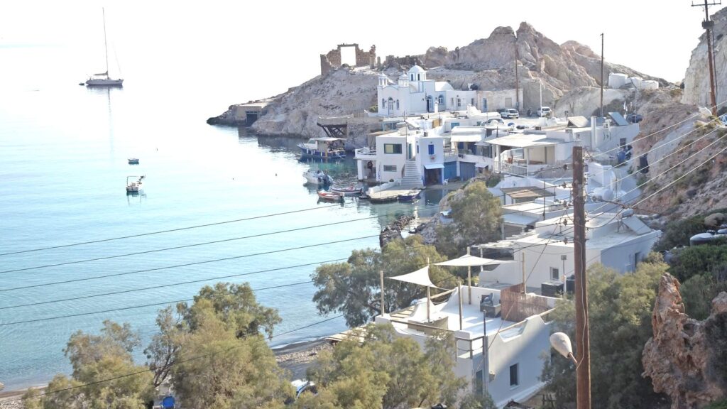 Milos offers a picturesque coastal village with white buildings perched on rocky shores, surrounded by clear blue waters. Sailboats dot the horizon, and ancient ruins crown the hilltop. Experience the magic of this hidden gem in your ultimate island guide.