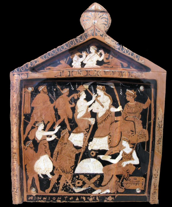 This ancient Greek ceramic plaque, reminiscent of the festive spirit of Apokries, depicts various figures, including women and men, engaging in lively activities. They are surrounded by decorative elements and Greek inscriptions, capturing the celebratory essence of the season.