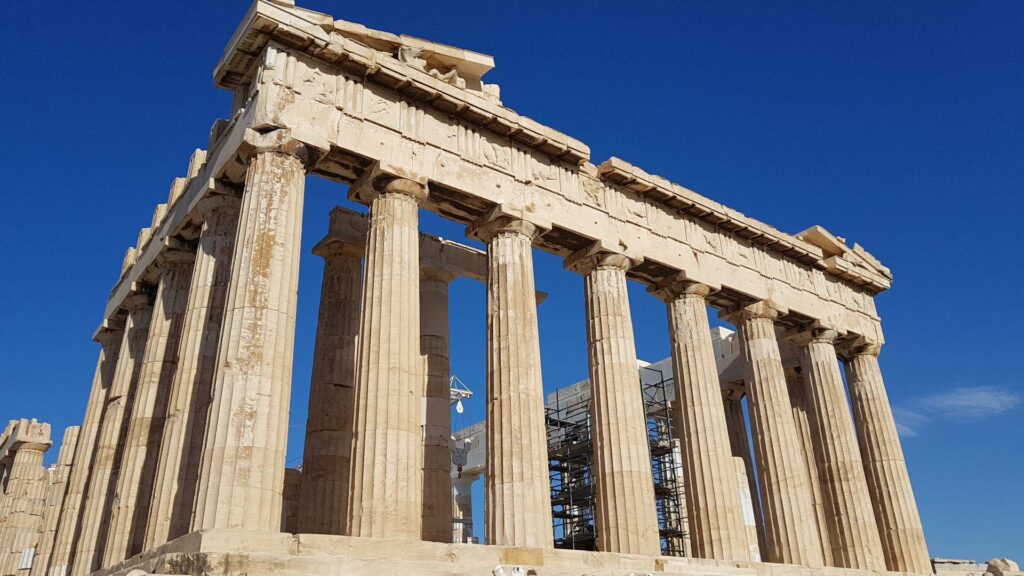 The Parthenon, an ancient Greek temple on the Acropolis of Athens, stands majestically with scaffolding visible against a clear blue sky. Check out 2025 updates in our Insider's Guide for the latest restoration insights and historical revelations.