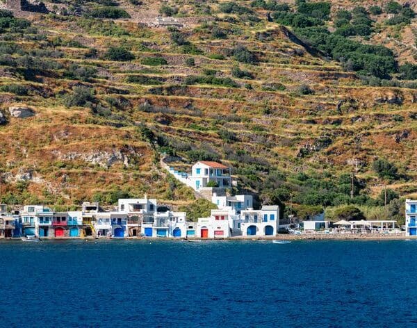Nestled on a rocky hillside, Klima Milos is a charming coastal village adorned with white and blue houses overlooking the clear blue sea.