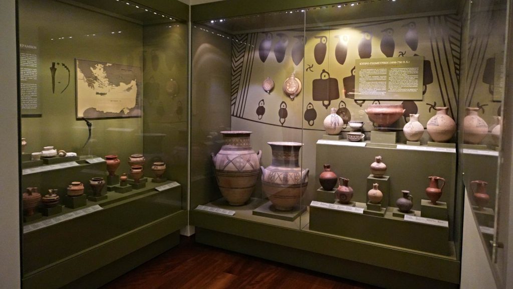 Museum exhibit of the Levantis Gallery displays ancient pottery and artifacts in glass cases, including large decorated vases, smaller vessels, a map, and informational panels on the walls—an essential stop when exploring what things to do in Nicosia Cyprus.